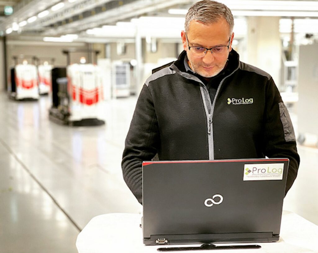 ProLog employee works with laptop on AGV project